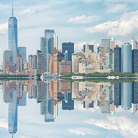 A city skyline is perfectly reflected on the calm water below by Manjik Pictures