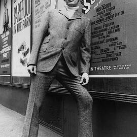 A Male Model Posing In Front Of An Advertisement by Horn & Griner